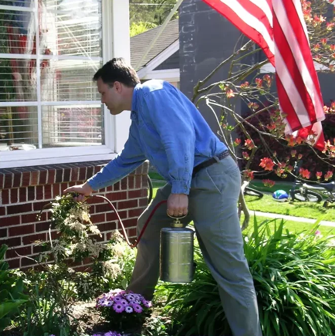 United Pest control technician spraying pest control chemicals
