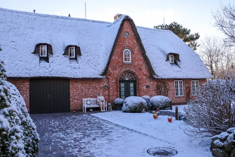 Snow-covered brick house in winter with sealed doors, windows, and landscaping to help pest-proof the home.