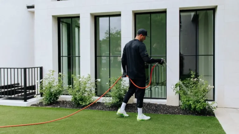 Pest control technician treating the exterior of a home